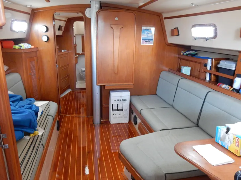 Slide: The Image of Interior of 1997 Island Packet 40 sailboat with wooden flooring and cozy seating. - 18