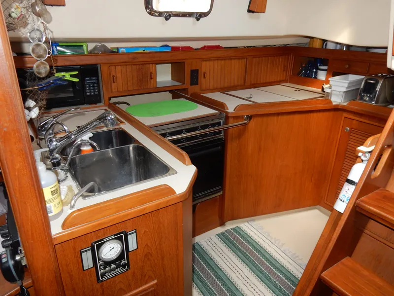 Slide: The Image of Island Packet 40 yacht kitchen, 1997 model, featuring wooden cabinetry and modern appliances. - 22