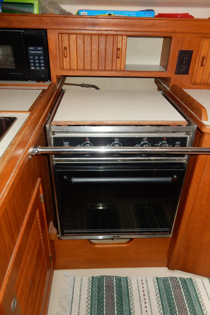 Slide: The Image of 1997 Island Packet 40 yacht kitchen with stove and wooden cabinetry. - 23