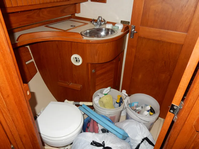 Slide: The Image of 1997 Island Packet 40 yacht bathroom with wooden cabinetry and storage items. - 24