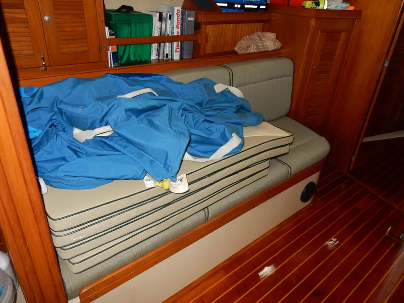 Slide: The Image of Interior of 1997 Island Packet 40 sailboat with cushions and blue fabric on wooden bench. - 25