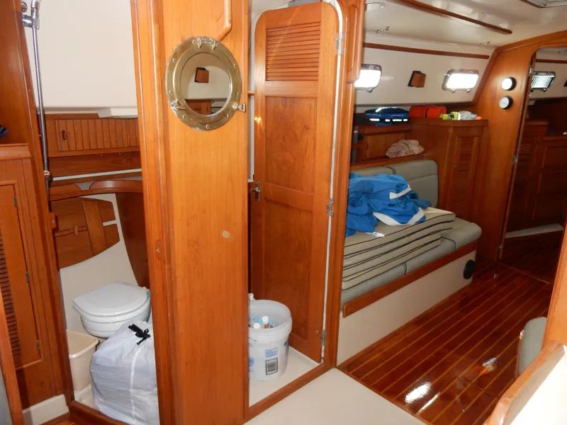 Slide: The Image of Interior of 1997 Island Packet 40 sailboat with wooden finishes and seating area. - 27
