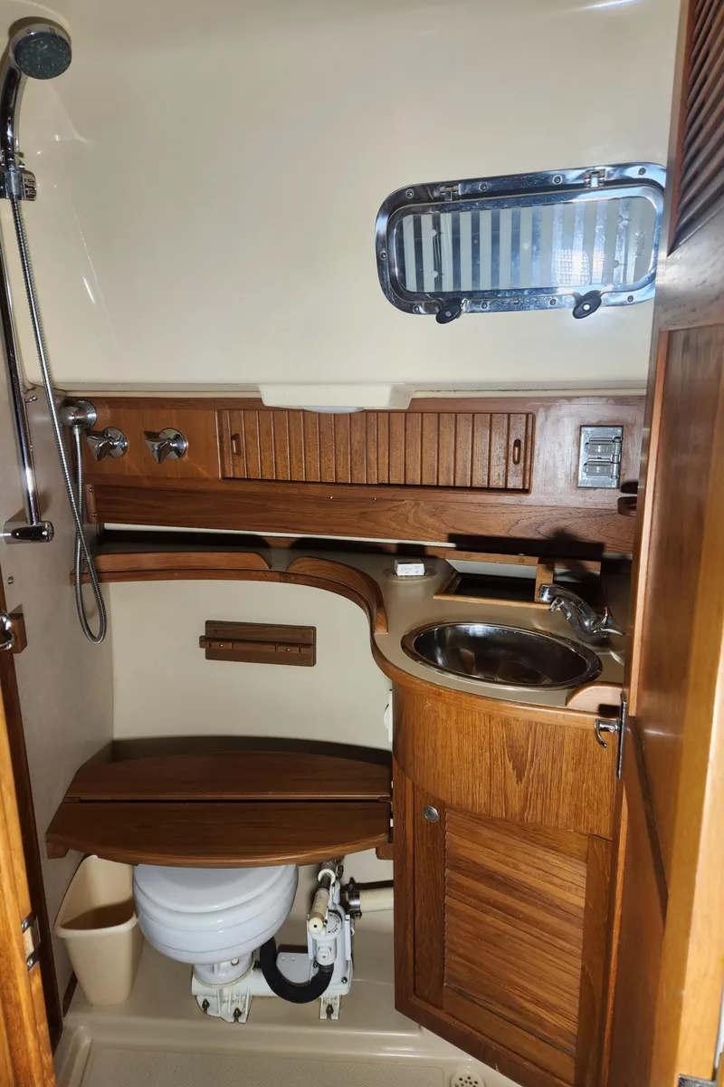 Slide: The Image of 1997 Island Packet 40 yacht bathroom with wooden cabinetry and stainless steel sink. - 28