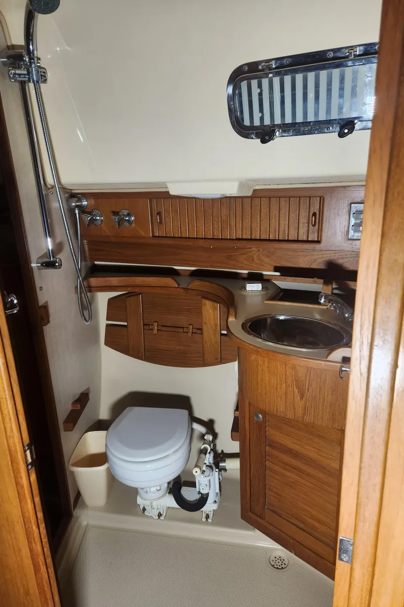 Slide: The Image of 1997 Island Packet 40 yacht bathroom with wooden cabinetry and compact fixtures. - 29