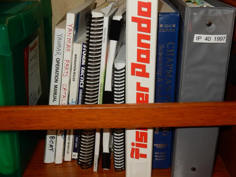 Slide: The Image of Books and manuals on a shelf, including a binder labeled "IP 40 1997." - 39