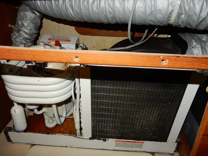 Slide: The Image of 1997 Island Packet 40 boat air conditioning unit with coiled pipes and ventilation ducts. - 45