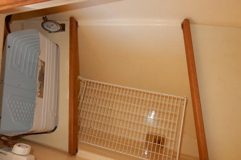 Slide: The Image of Interior storage area of a 1997 Island Packet 40 sailboat with wooden supports and a wire rack. - 47