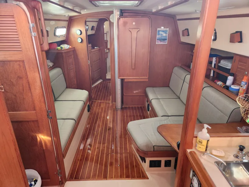 Slide: The Image of Interior of 1997 Island Packet 40 sailboat with wooden finishes and cushioned seating. - 6