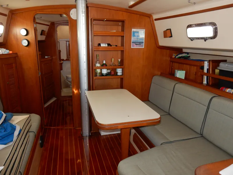 Slide: The Image of Interior of 1997 Island Packet 40 sailboat with wooden furnishings and cozy seating area. - 7