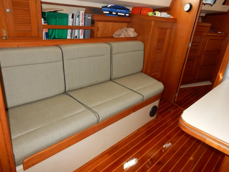 Slide: The Image of Interior of 1997 Island Packet 40 sailboat with cushioned seating and wooden flooring. - 8