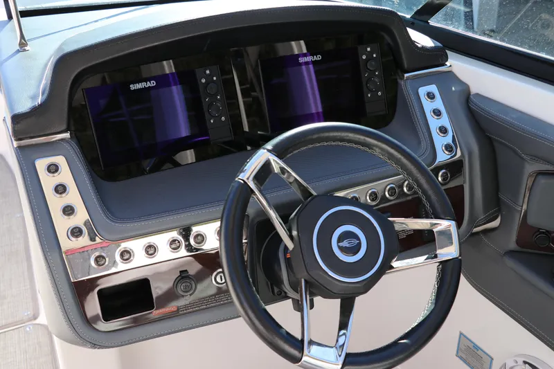 Slide: The Image of 2019 Chaparral 297 SSX boat dashboard with dual Simrad displays and steering wheel. - 17
