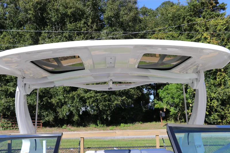 Slide: The Image of 2019 Chaparral 297 SSX boat with sleek hardtop against a lush green backdrop. - 25