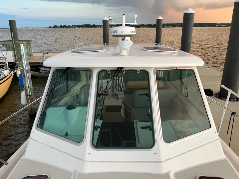 Slide: The Image of 2013 Back Cove 34 boat docked at marina with scenic water view. - 12