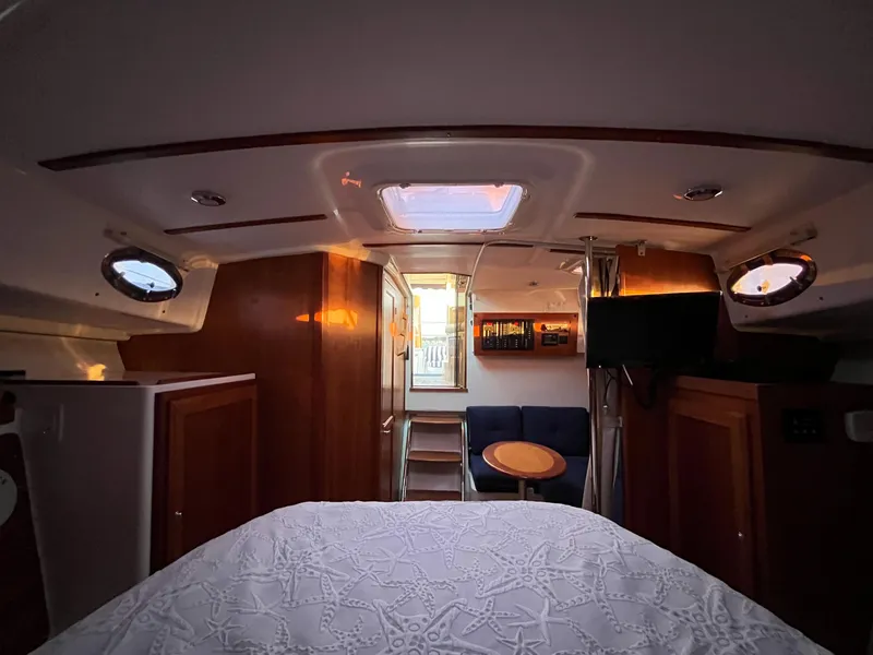 Slide: The Image of Interior of 2013 Back Cove 34 boat, featuring cozy cabin with bed and seating area. - 15