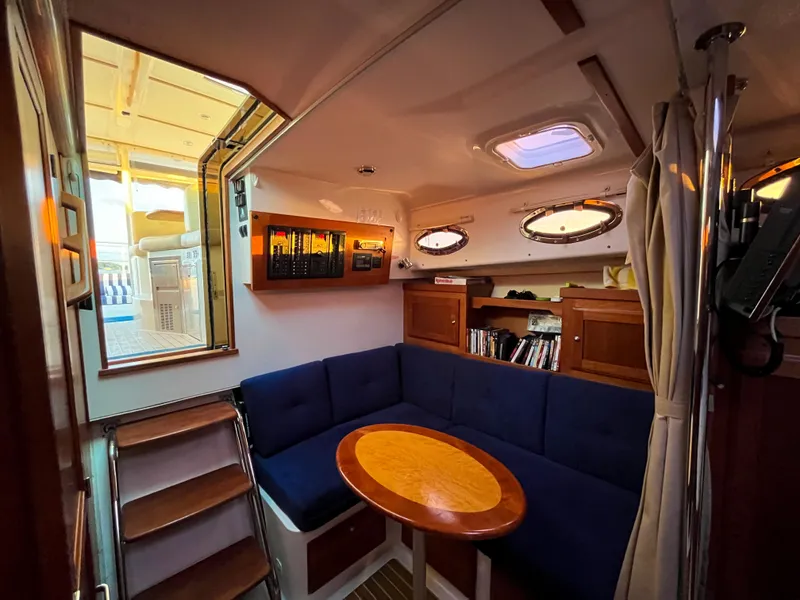 Slide: The Image of 2013 Back Cove 34 yacht interior with blue seating, wooden table, and nautical decor. - 19