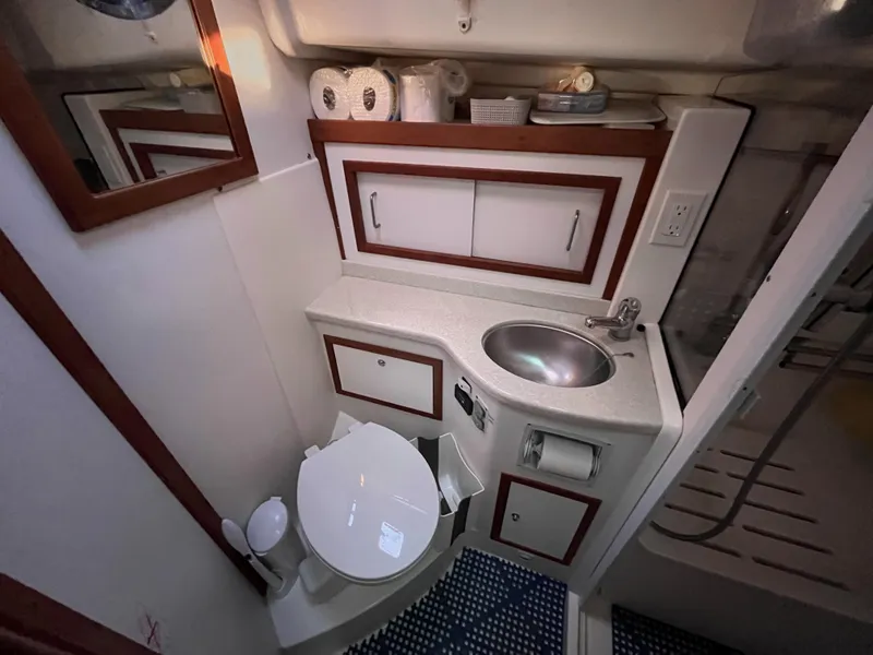 Slide: The Image of 2013 Back Cove 34 yacht bathroom with sink, toilet, and storage cabinets. - 23