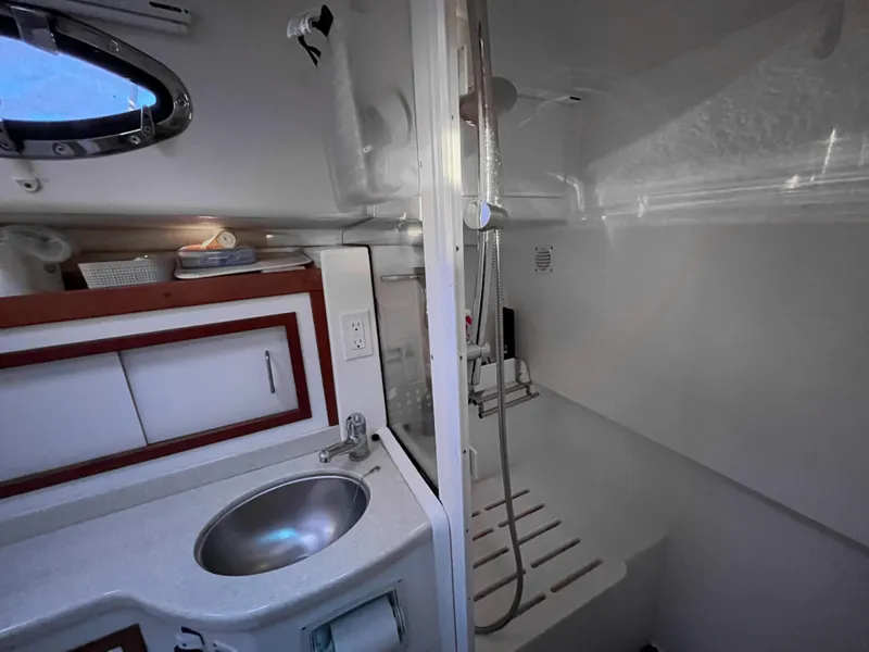 Slide: The Image of 2013 Back Cove 34 yacht bathroom with sink, shower, and storage cabinets. - 24