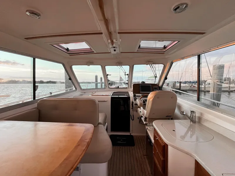 Slide: The Image of Interior of 2013 Back Cove 34 boat with helm, seating, and marina view. - 29