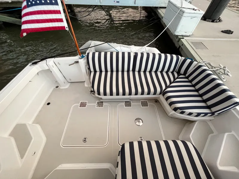 Slide: The Image of 2013 Back Cove 34 boat with striped seating and American flag at dock. - 34