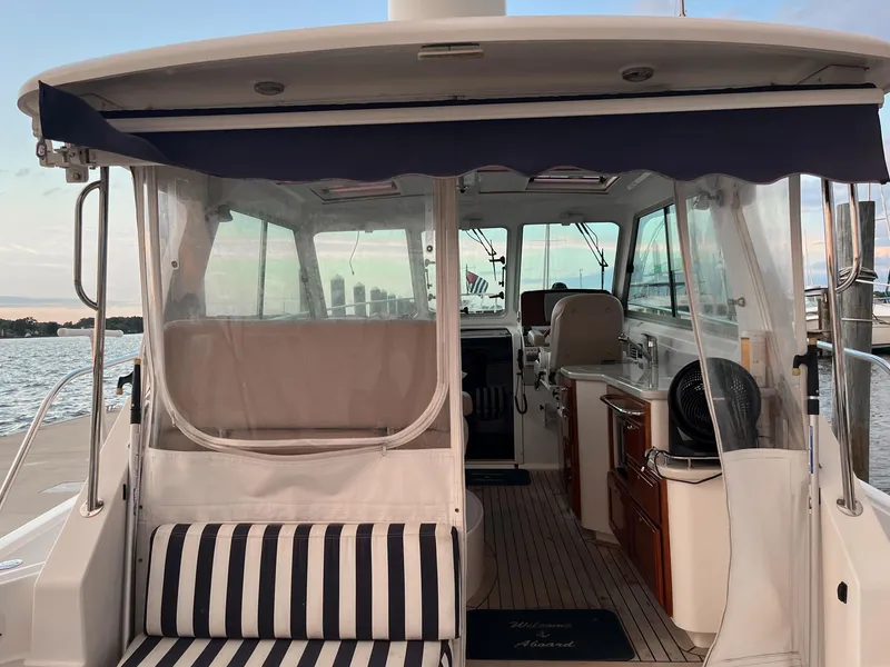 Slide: The Image of 2013 Back Cove 34 boat interior with striped seating and clear canopy. - 36