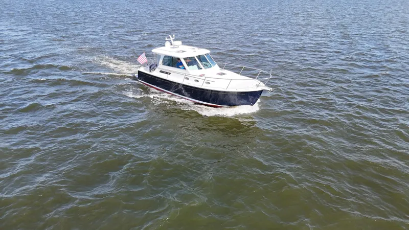 Slide: The Image of 2013 Back Cove 34 cruising on open water with American flag. - 4