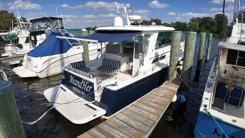 Slide: The Image of 2013 Back Cove 34 boat docked at marina with blue canopy. - 43