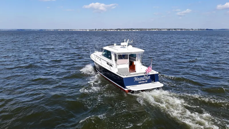 Slide: The Image of 2013 Back Cove 34 boat cruising on open water under a clear sky. - 6