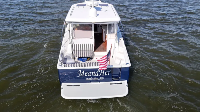 Slide: The Image of 2013 Back Cove 34 boat on water, rear view with American flag. - 9