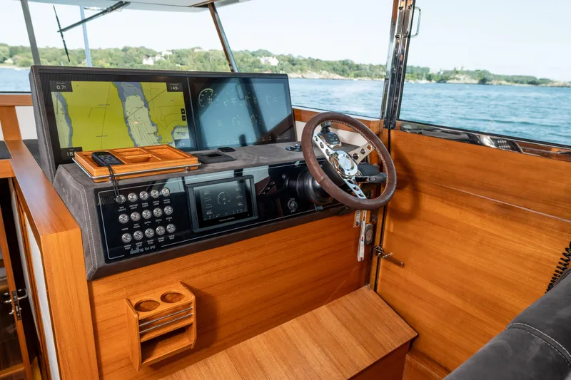 Slide: The Image of Delta Powerboats 54 IPS 2017 helm with navigation screens and wooden dashboard. - 30