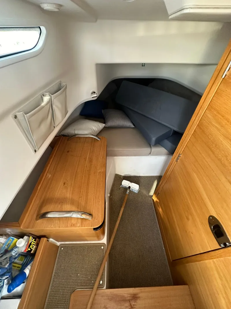 Slide: The Image of Cozy cabin interior of 2021 Nimbus C9 boat with wooden furnishings and seating area. - 25