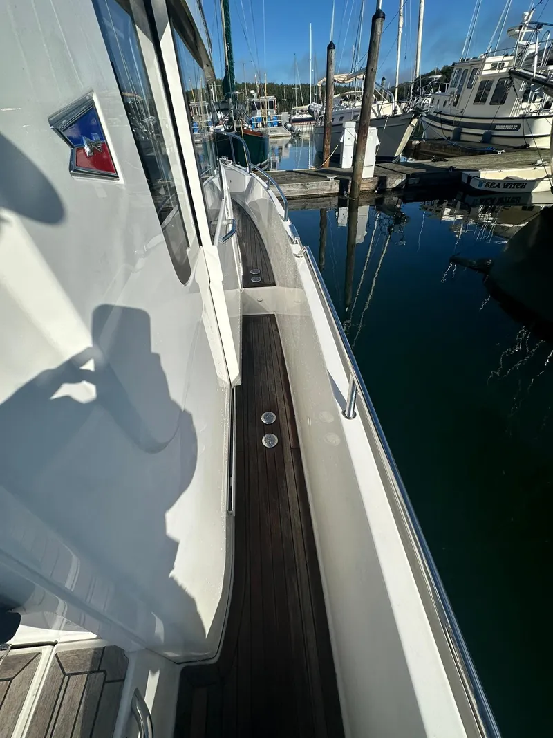 Slide: The Image of Nimbus C9 2021 boat docked at marina, side view with wooden deck. - 6