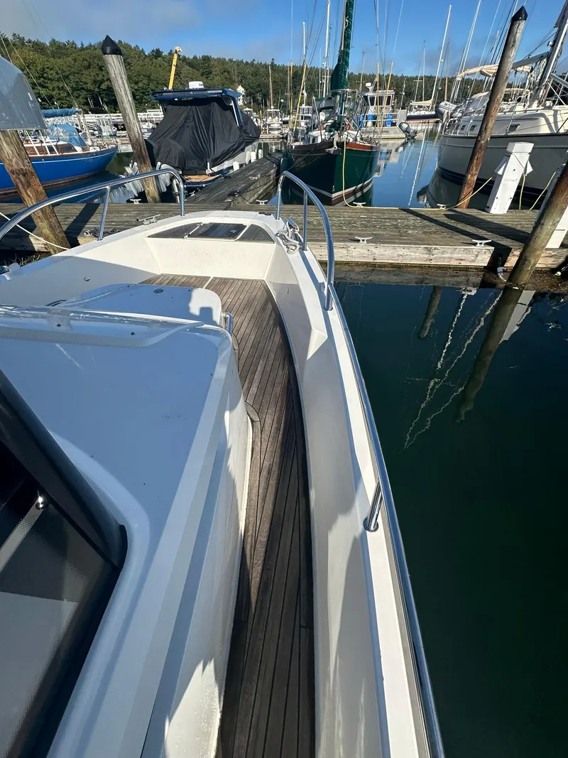 Slide: The Image of Nimbus C9 2021 boat docked at marina, featuring sleek design and wooden deck. - 9