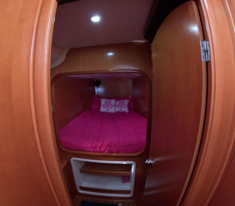 Slide: The Image of Cozy cabin interior of 2004 Lagoon 380 catamaran with pink bedding and wooden finish. - 13