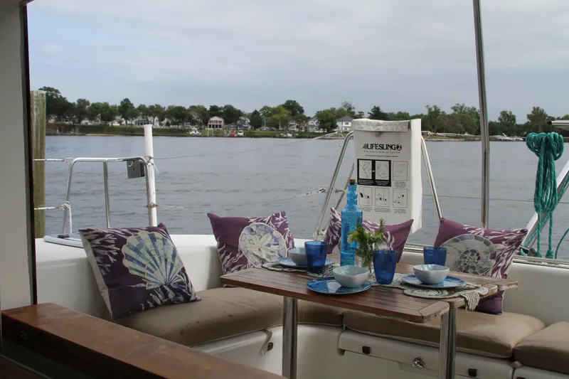 Slide: The Image of Cozy seating area on 2004 Lagoon 380 catamaran with decorative pillows and tableware. - 15