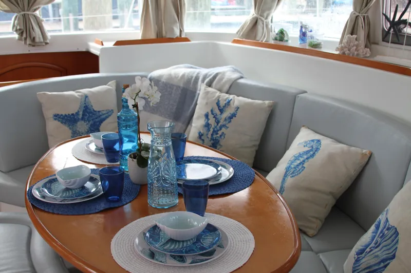 Slide: The Image of Cozy dining area on 2004 Lagoon 380 catamaran with nautical-themed decor. - 20
