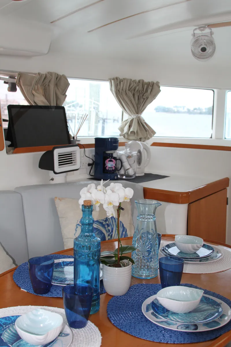 Slide: The Image of Interior of 2004 Lagoon 380 yacht with elegant dining setup and nautical decor. - 23