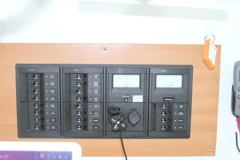 Slide: The Image of Electrical panel on a 2004 Lagoon LAGOON 380 catamaran, featuring circuit breakers and meters. - 25