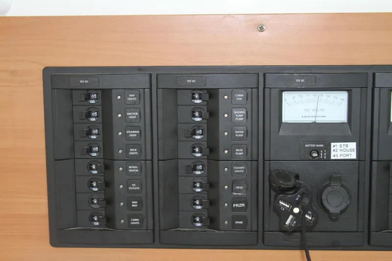 Slide: The Image of Electrical control panel on a 2004 Lagoon LAGOON 380 catamaran, featuring switches and voltmeter. - 28