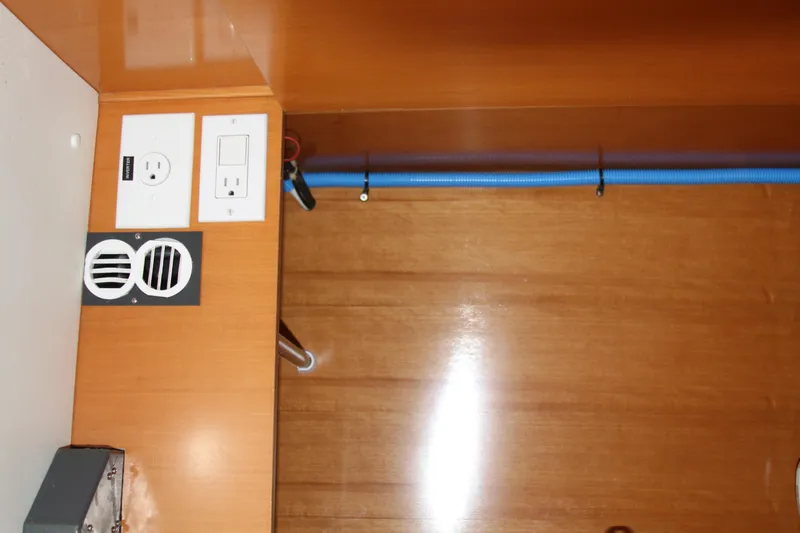 Slide: The Image of Electrical outlets and vents on a wooden panel in a 2004 Lagoon 380 boat. - 37