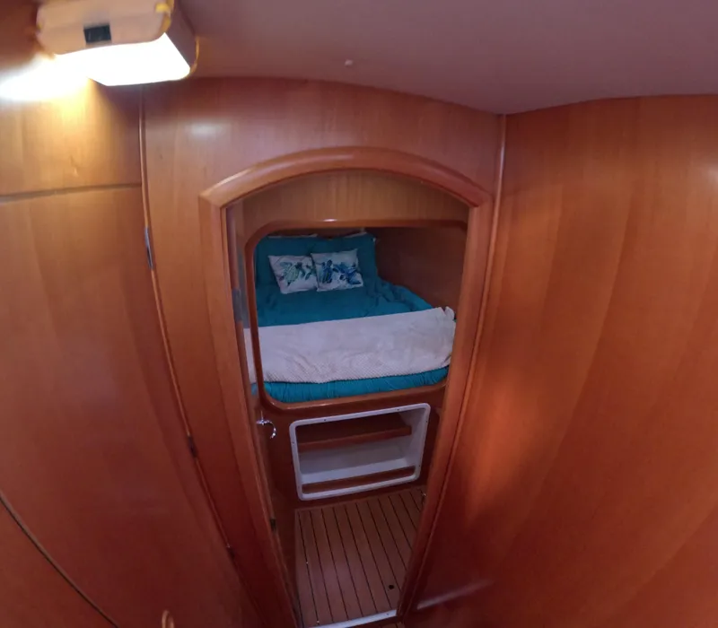 Slide: The Image of Cozy cabin interior of 2004 Lagoon 380 catamaran with wooden finish and blue bedding. - 6