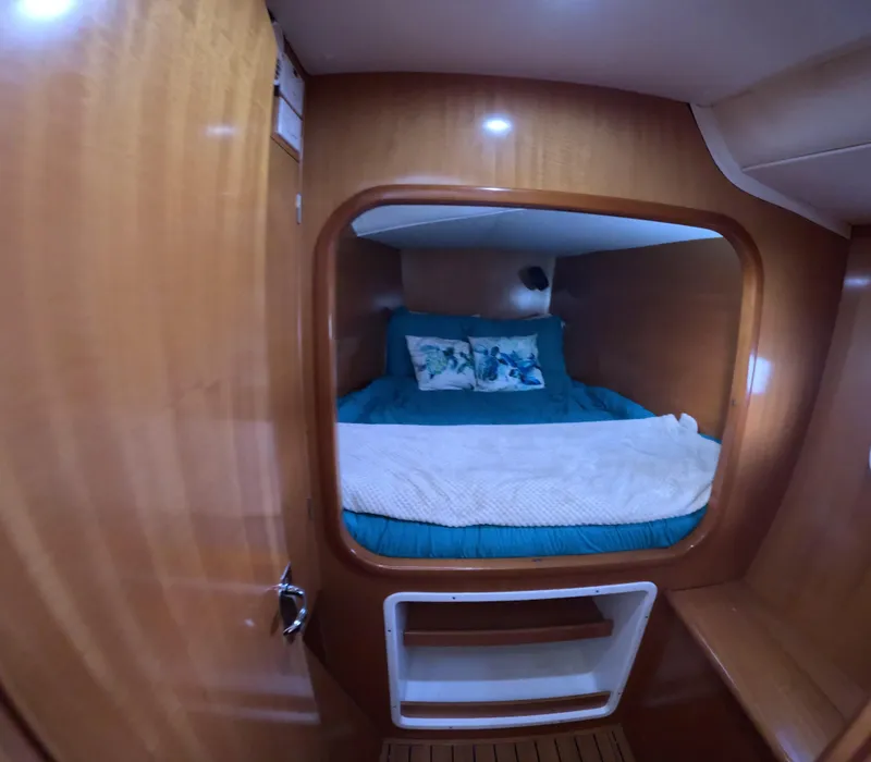 Slide: The Image of Cozy cabin interior of 2004 Lagoon 380 catamaran with wooden finish and comfortable bedding. - 7