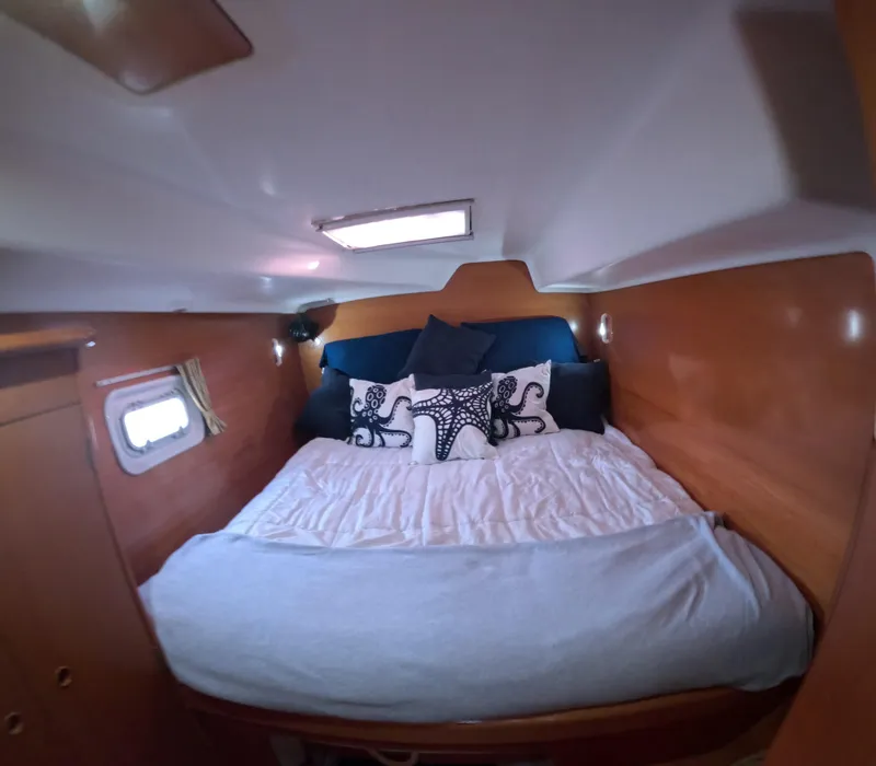 Slide: The Image of Cozy bedroom in 2004 Lagoon 380 yacht with nautical-themed pillows and wooden interior. - 8