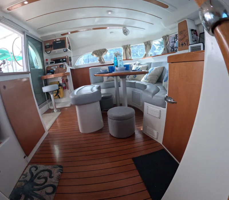 Slide: The Image of Interior of 2004 Lagoon 380 catamaran with cozy seating and wooden flooring. - 9