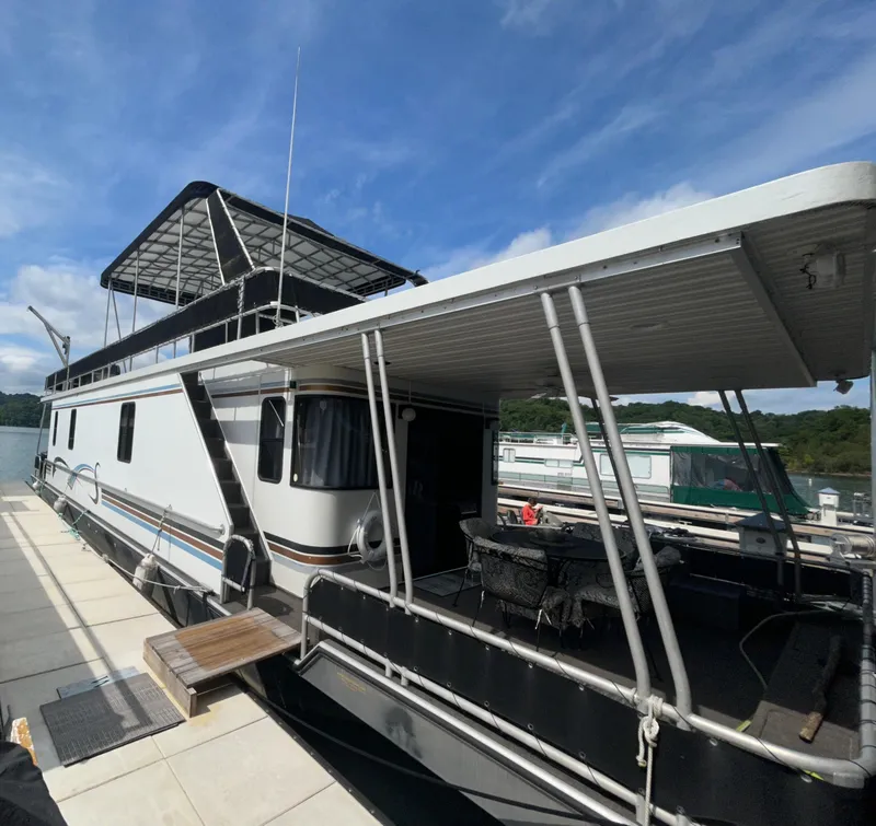 Slide: The Image of 1999 Lakeview houseboat docked under a clear blue sky. - 1