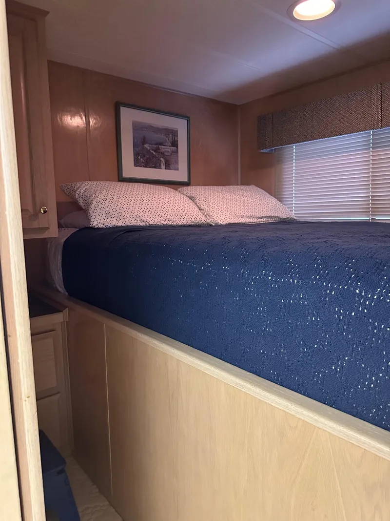 Slide: The Image of 1999 Lakeview houseboat bedroom with cozy bed, wooden interior, and framed artwork. - 10