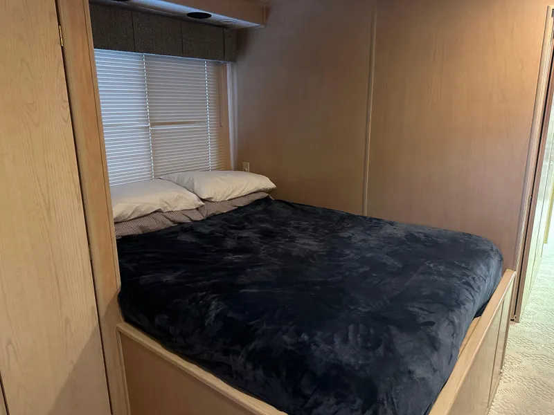 Slide: The Image of Cozy bedroom in 1999 Lakeview houseboat with plush bedding and window blinds. - 12