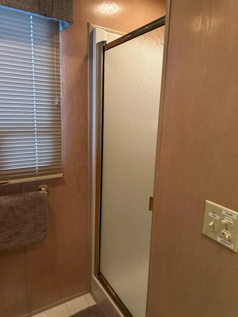 Slide: The Image of Bathroom interior of a 1999 Lakeview houseboat with shower and window blinds. - 16