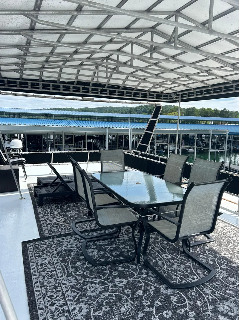 Slide: The Image of Outdoor dining area on 1999 Lakeview houseboat with glass table and chairs under canopy. - 22