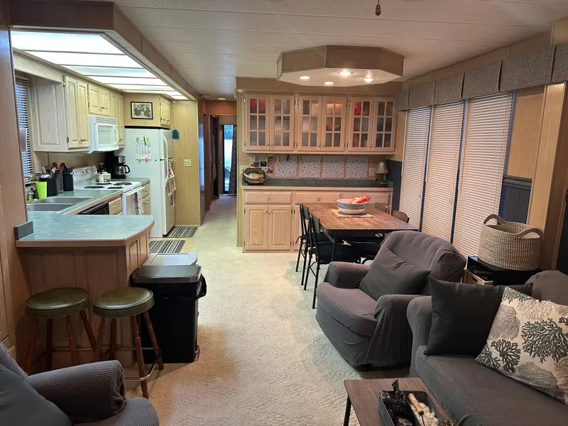 Slide: The Image of Cozy 1999 Lakeview houseboat interior with kitchen, dining area, and comfortable seating. - 5