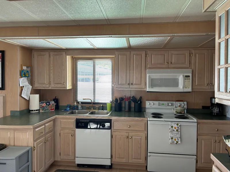 Slide: The Image of Kitchen interior of a 1999 Lakeview houseboat with wooden cabinets and modern appliances. - 6